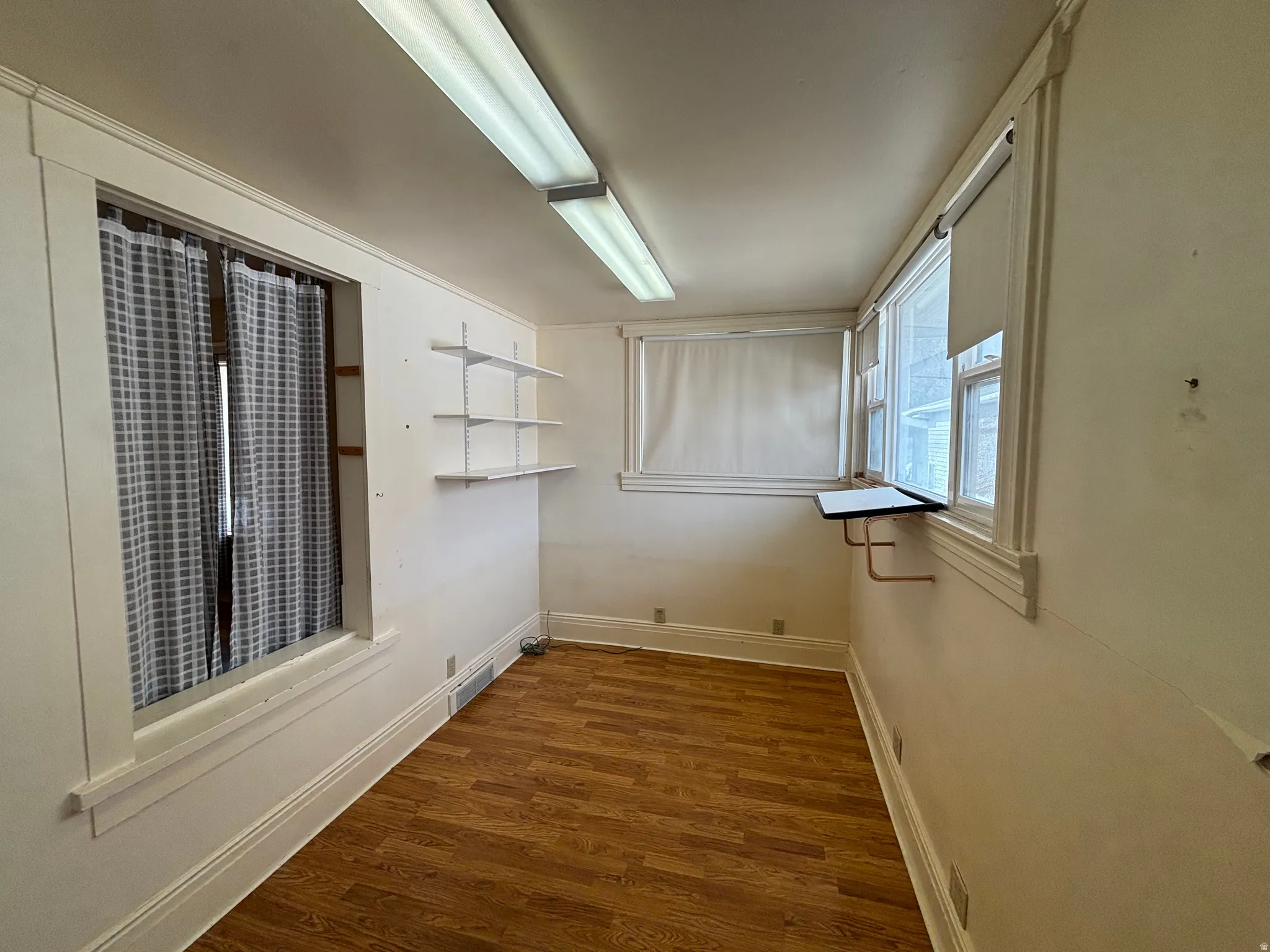 Empty room with dark wood finished floors and baseboards