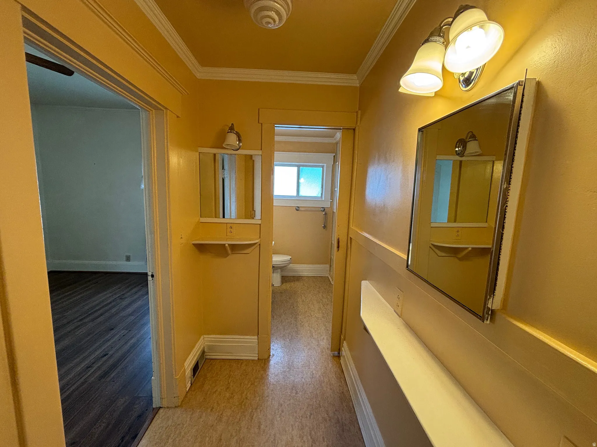 Corridor featuring ornamental molding and light wood-style floors