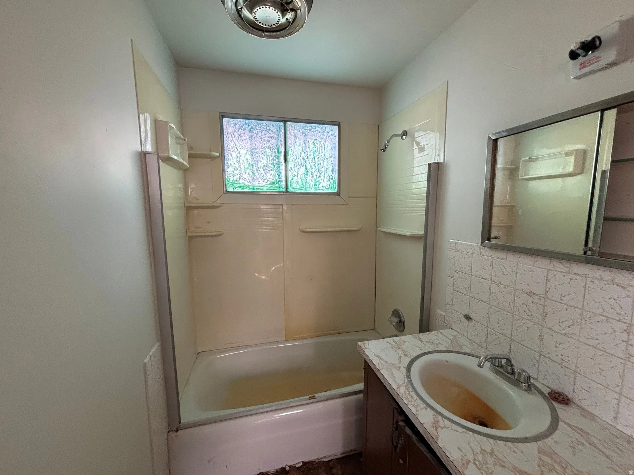 Full bathroom featuring vanity,  shower combination, and tasteful backsplash