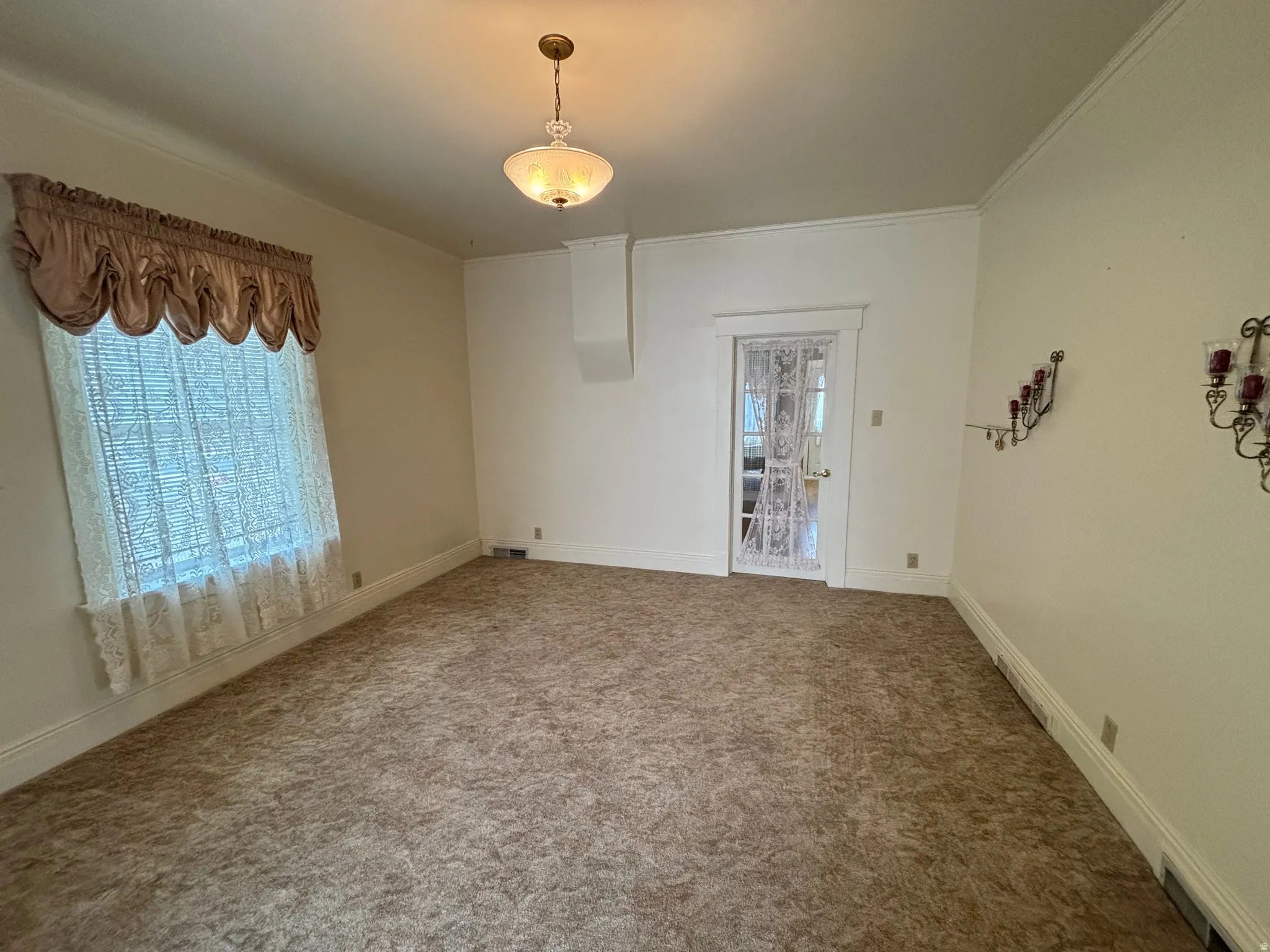 Carpeted empty room featuring baseboards and ornamental molding