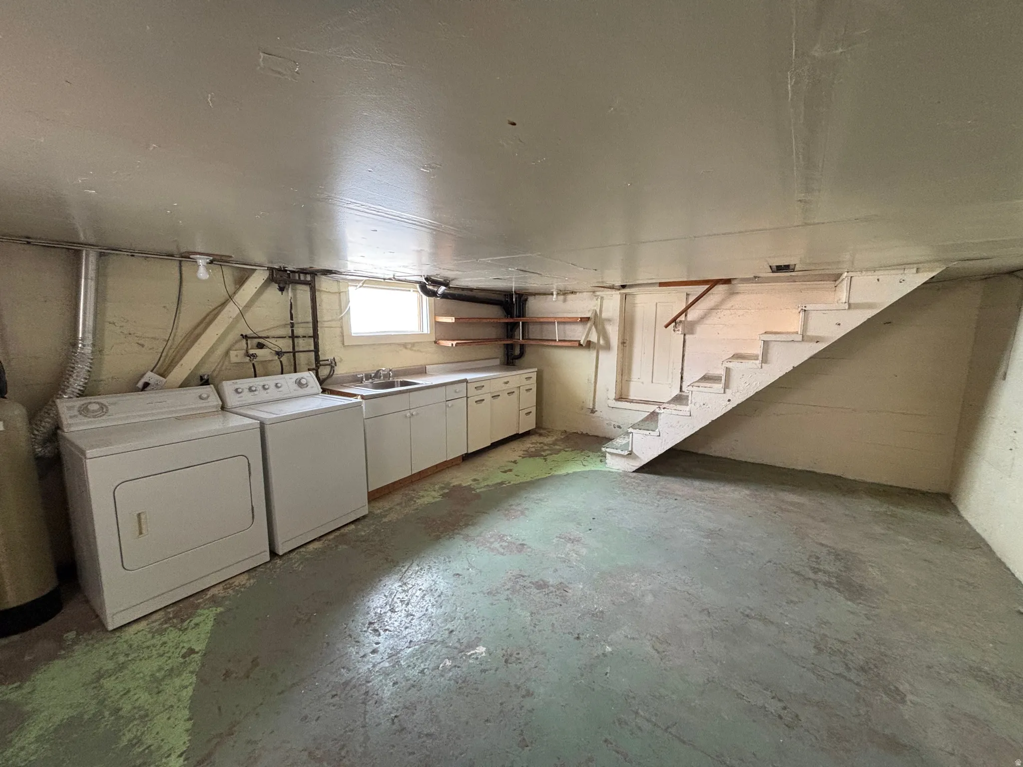 Below grade area with stairs and separate washer and dryer