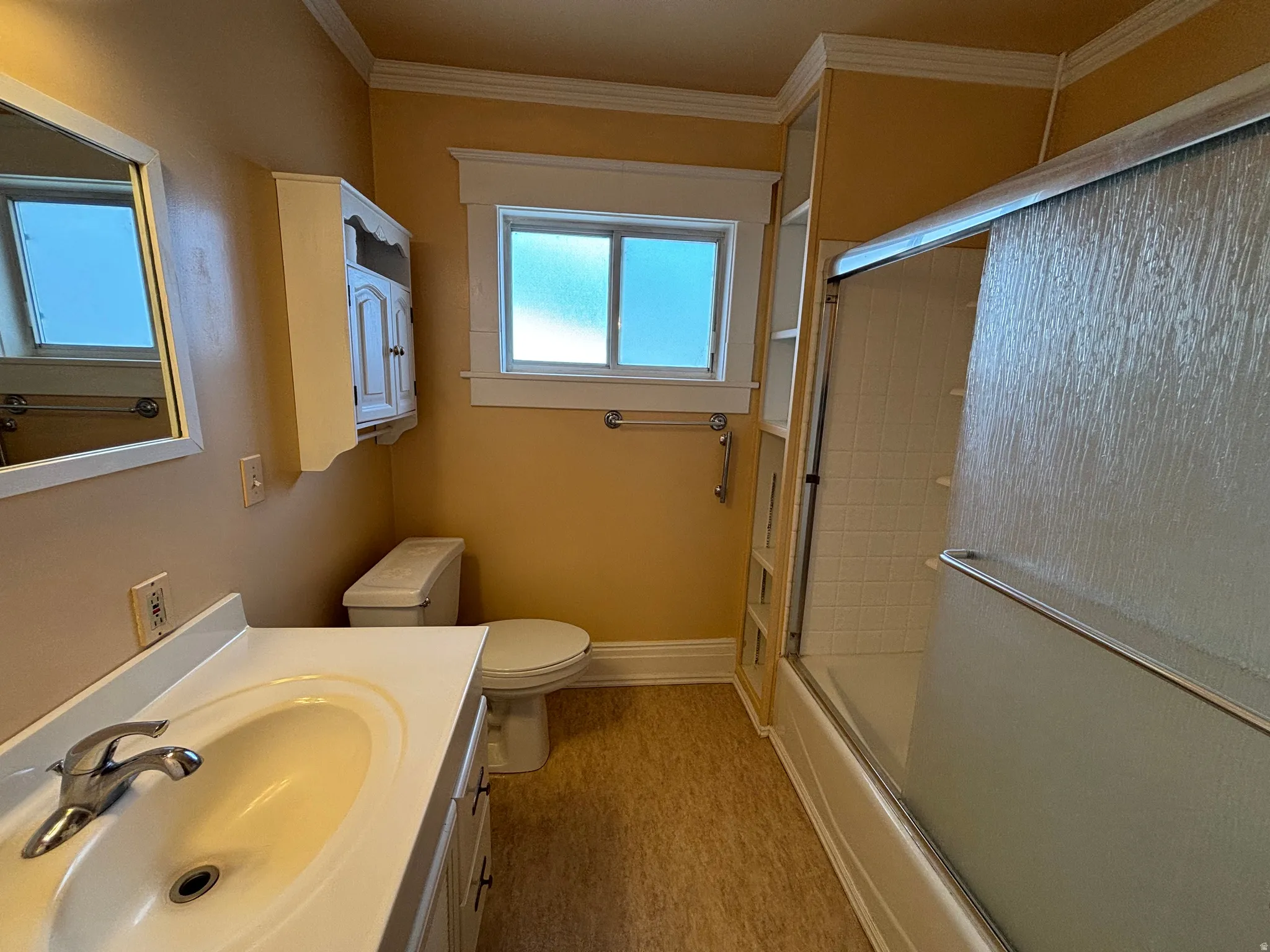 Full bathroom featuring vanity, enclosed tub / shower combo, ornamental molding, and light wood-type flooring