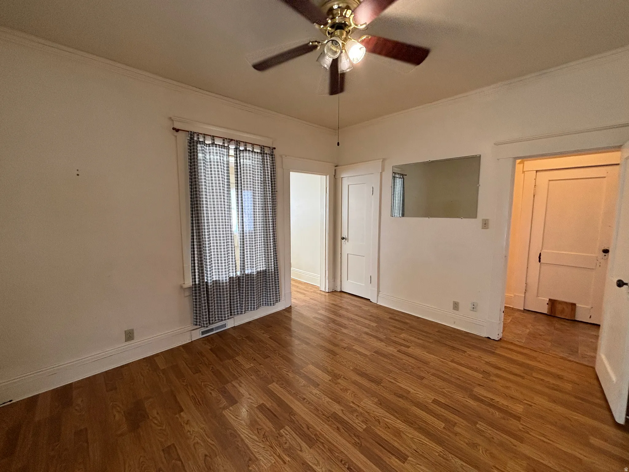 Spare room featuring ornamental molding, ceiling fan, and wood finished floors
