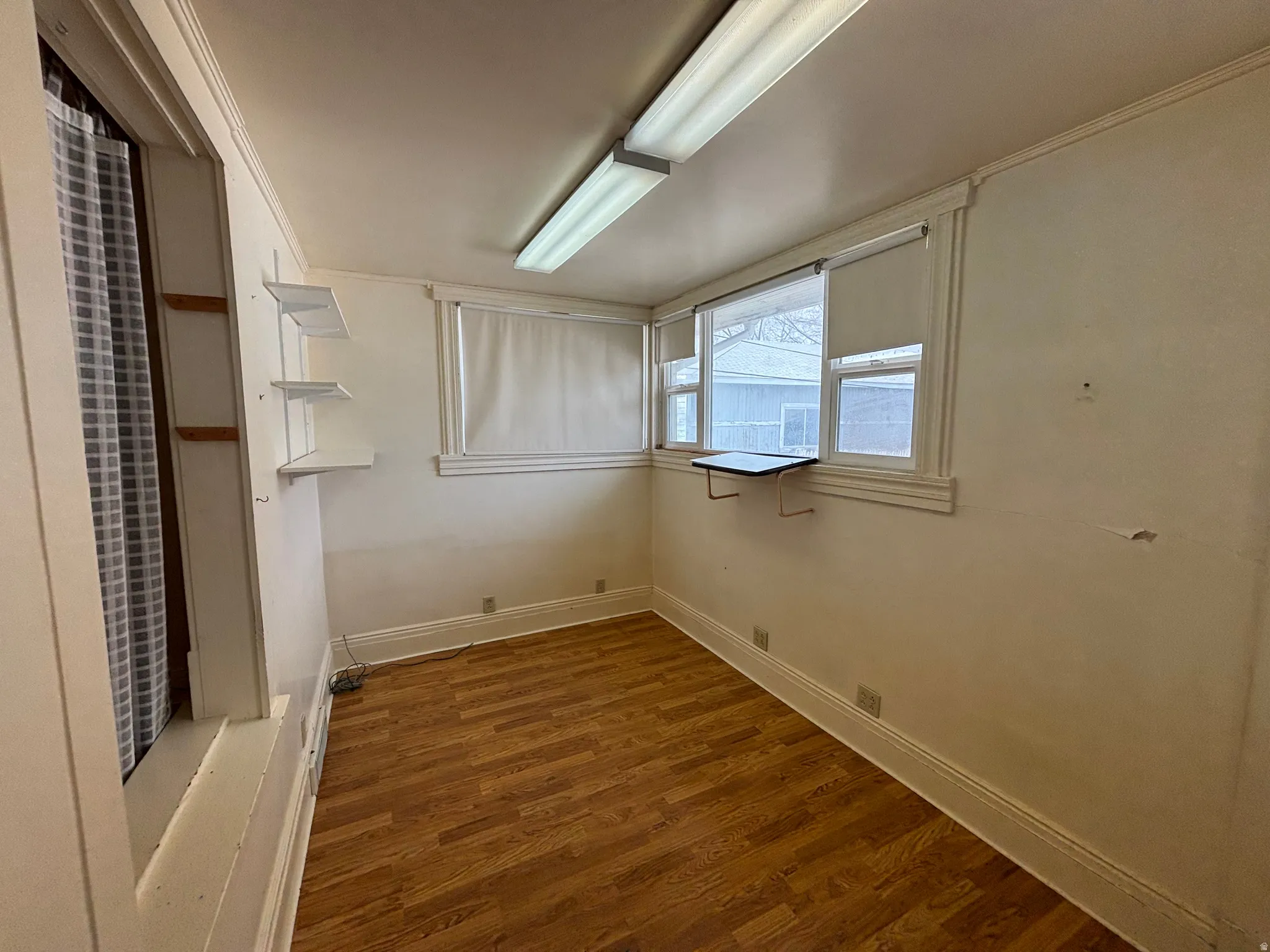 Unfurnished room featuring dark wood finished floors and baseboards