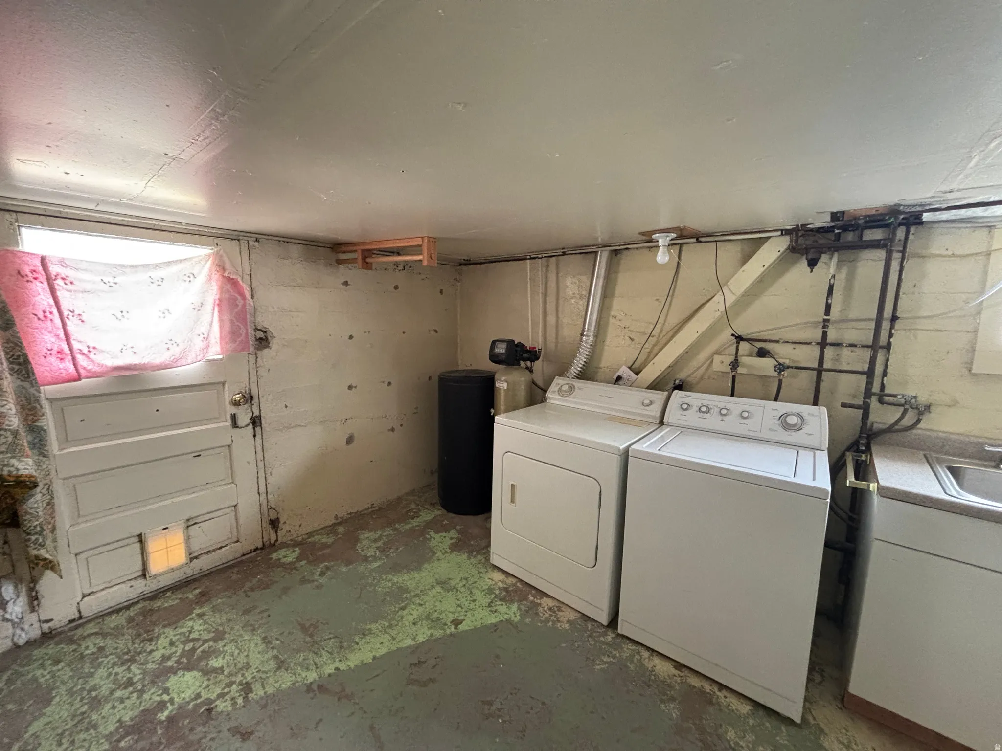 Laundry area featuring unfinished concrete flooring and independent washer and dryer