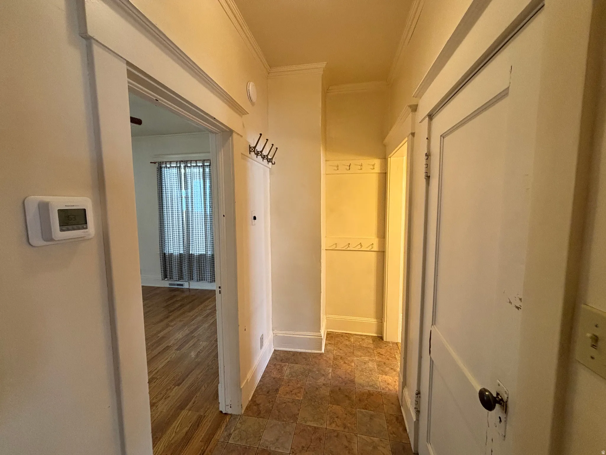 Corridor with crown molding and stone finish flooring