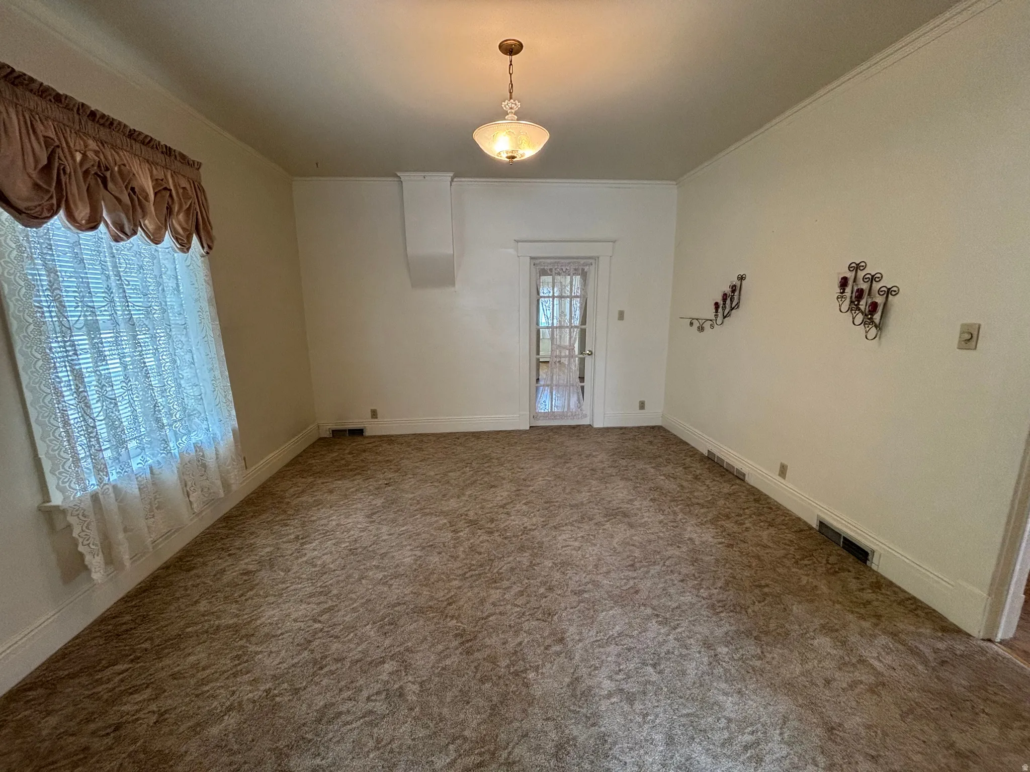 Unfurnished dining area with carpet, healthy amount of natural light, and crown molding