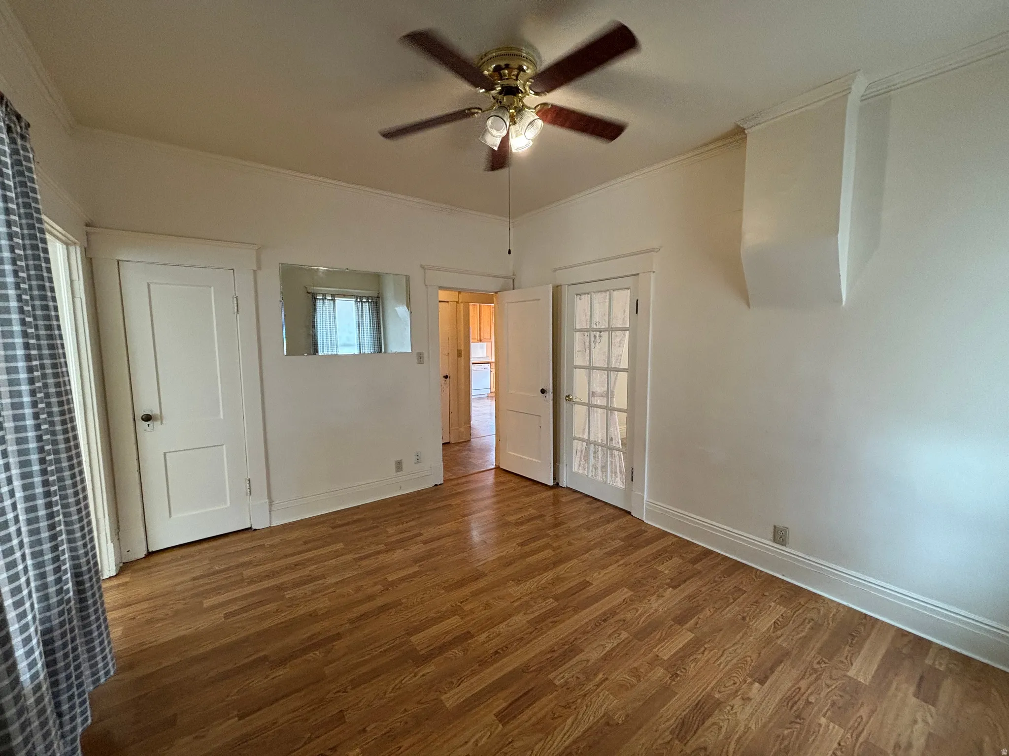 Unfurnished room featuring crown molding, wood finished floors, and a ceiling fan