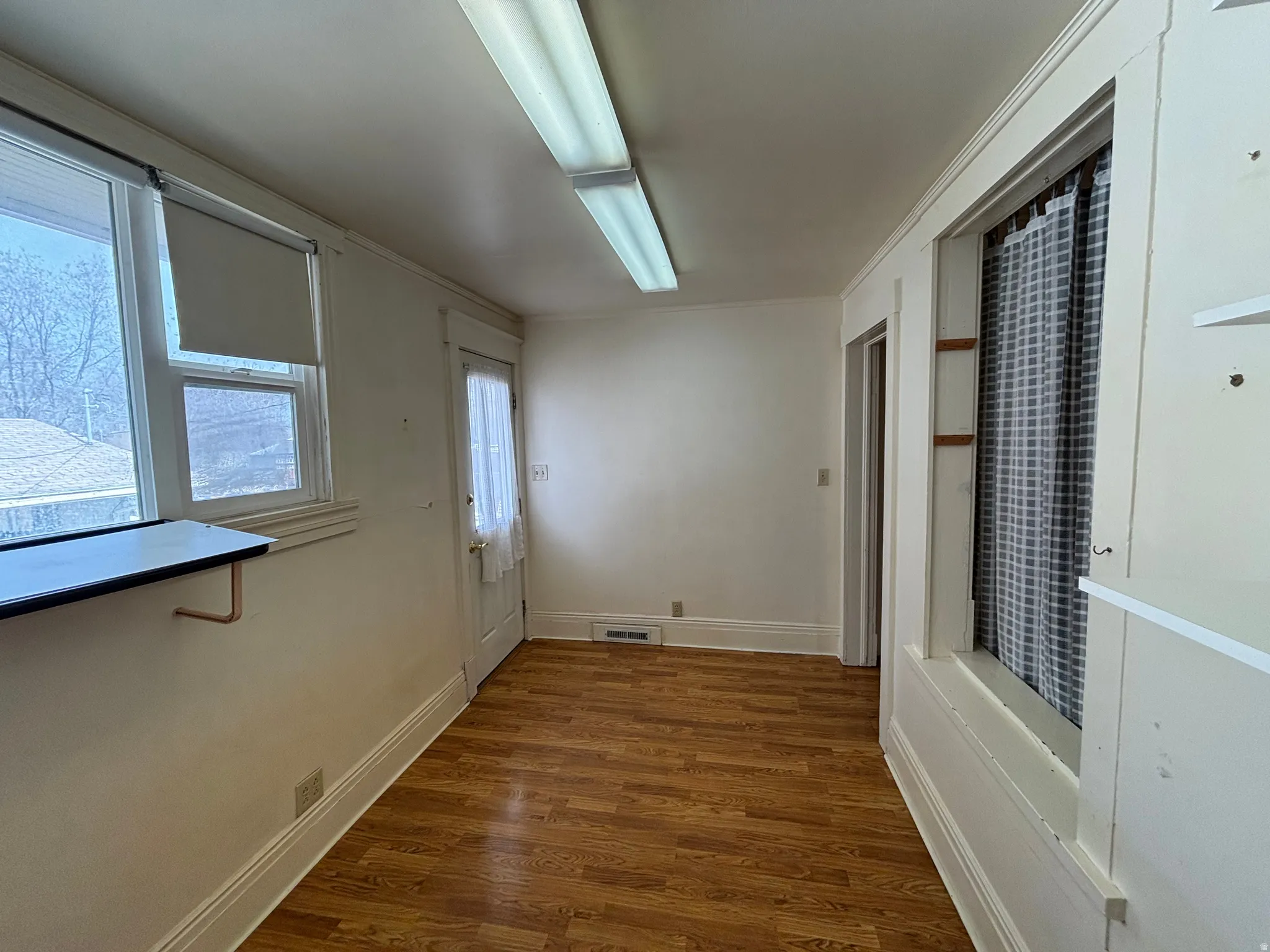 Doorway featuring wood finished floors and ornamental molding