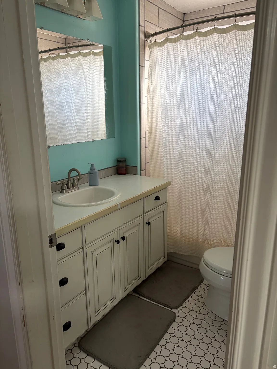 Bathroom featuring vanity, a shower with curtain, and light tile patterned floors