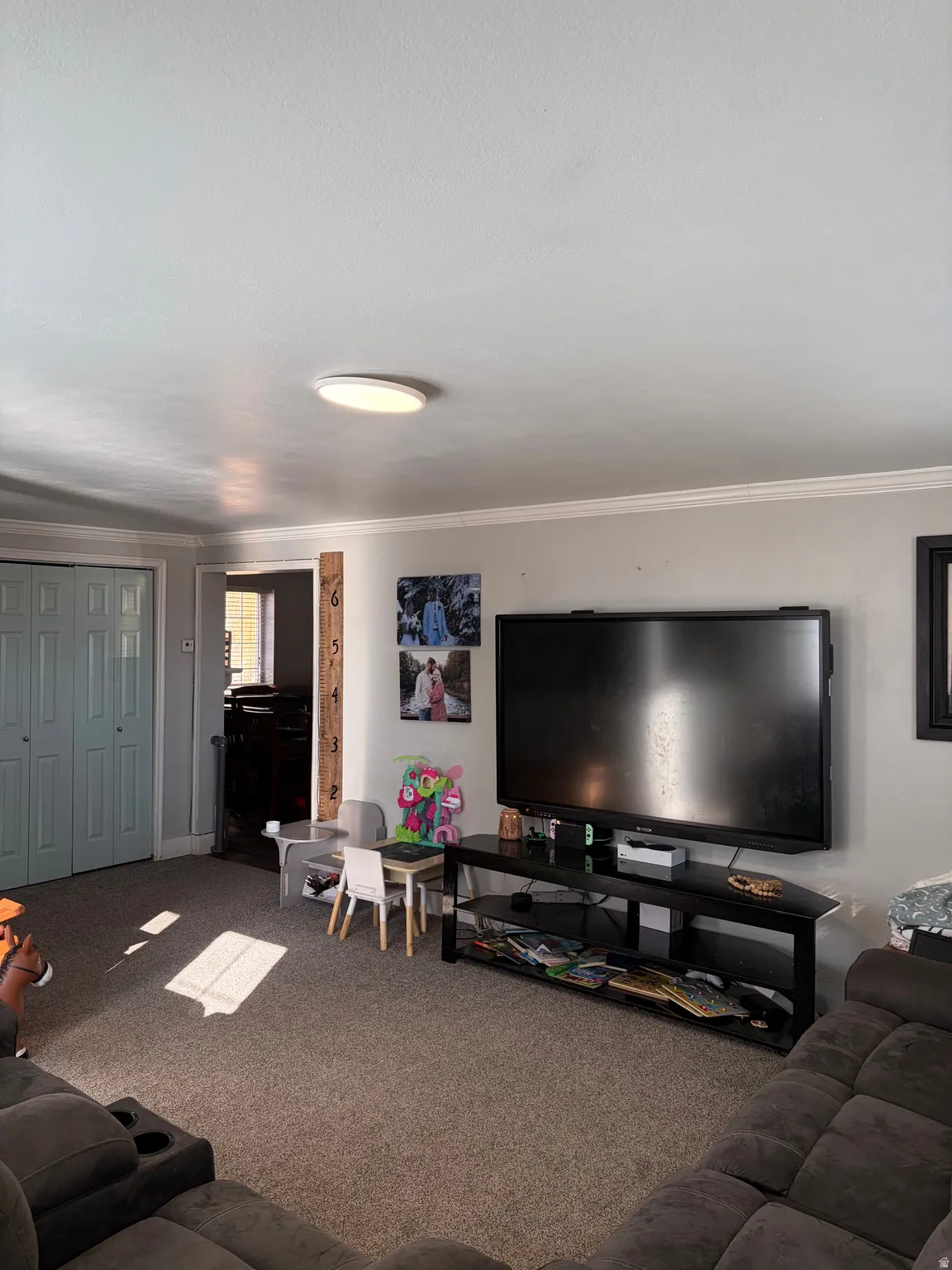 Living room featuring carpet flooring and ornamental molding