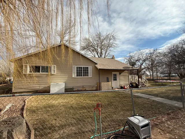 View of side of home with a fenced front yard and a shingled roof