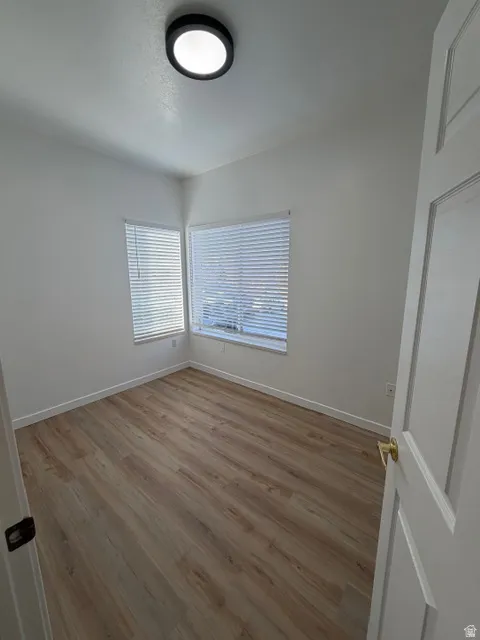 Unfurnished room with light wood finished floors and baseboards