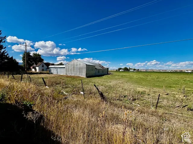 View of yard featuring a pole building, an outdoor structure, and a view of countryside