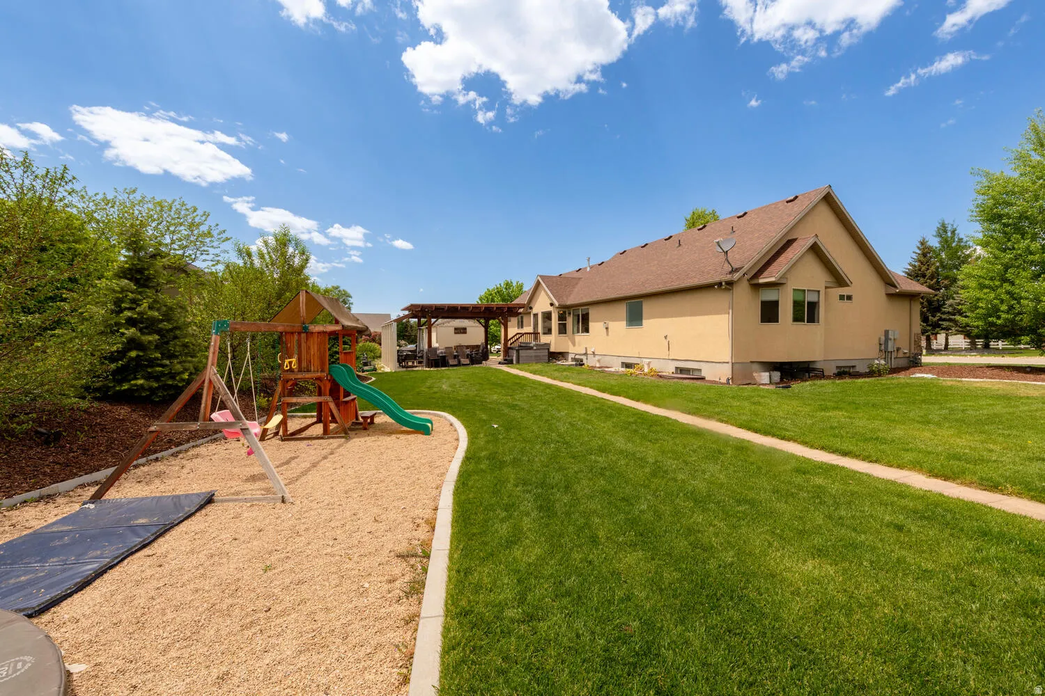 Community playground with a lawn and a pergola