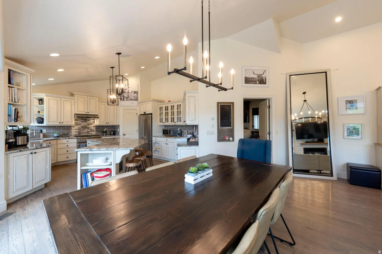 Dining area with a chandelier, recessed lighting, light wood-style flooring, and high vaulted ceiling