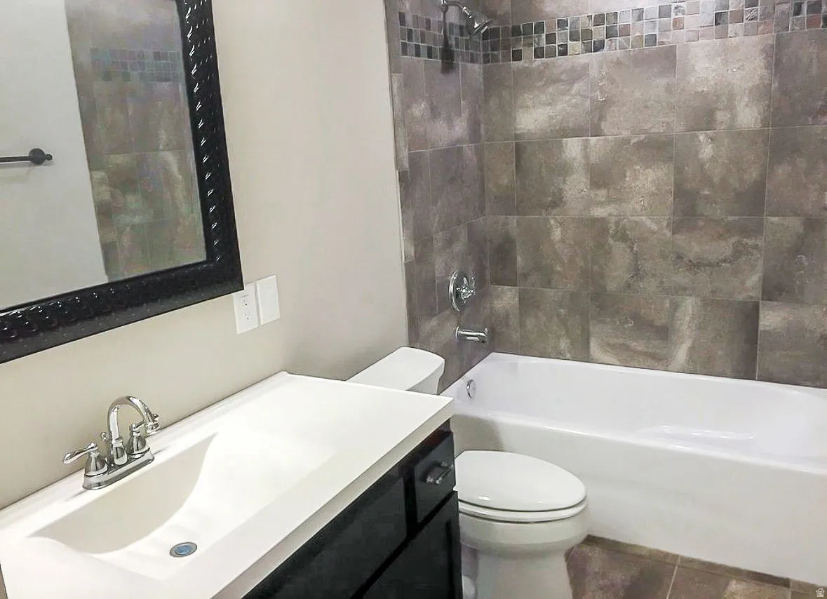 Bathroom with shower / washtub combination, vanity, and tile patterned flooring