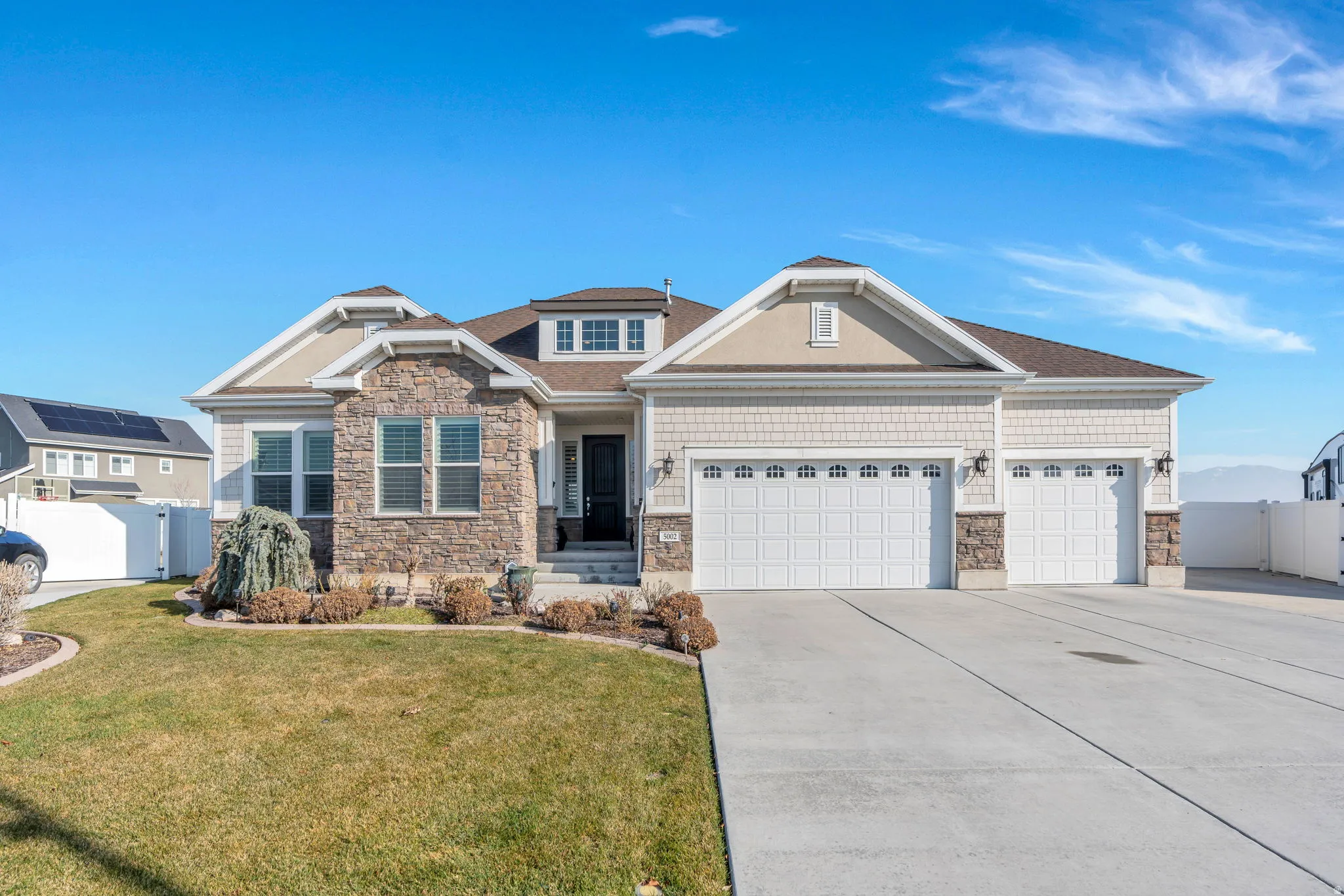 Craftsman house featuring stone siding, concrete driveway, and an attached garage