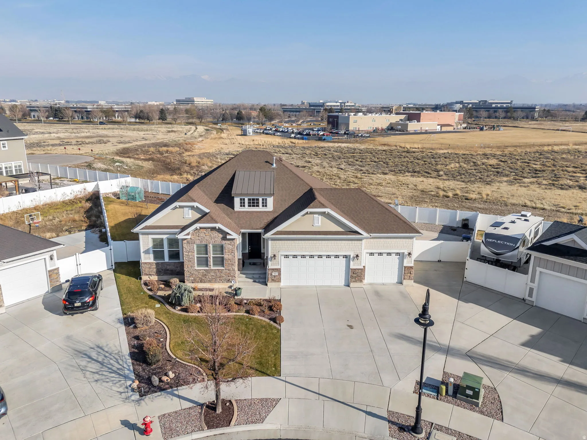 View of front of property featuring stone siding, concrete driveway, and a garage