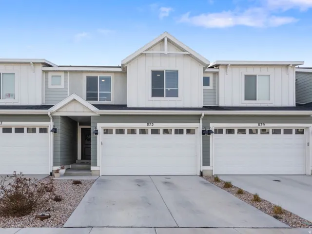 View of front of property featuring board and batten siding, concrete driveway, and a garage