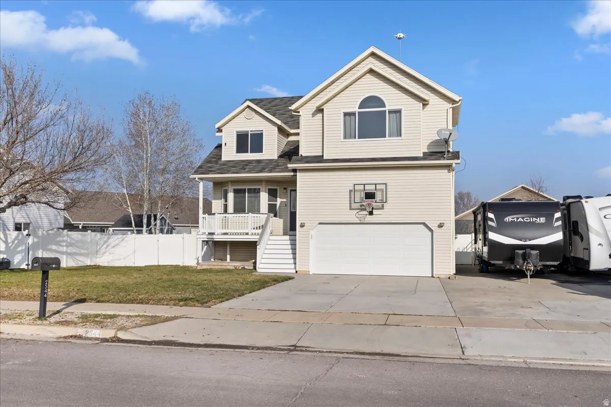 Traditional home featuring concrete driveway, a shingled roof, stairway, a garage, and a porch