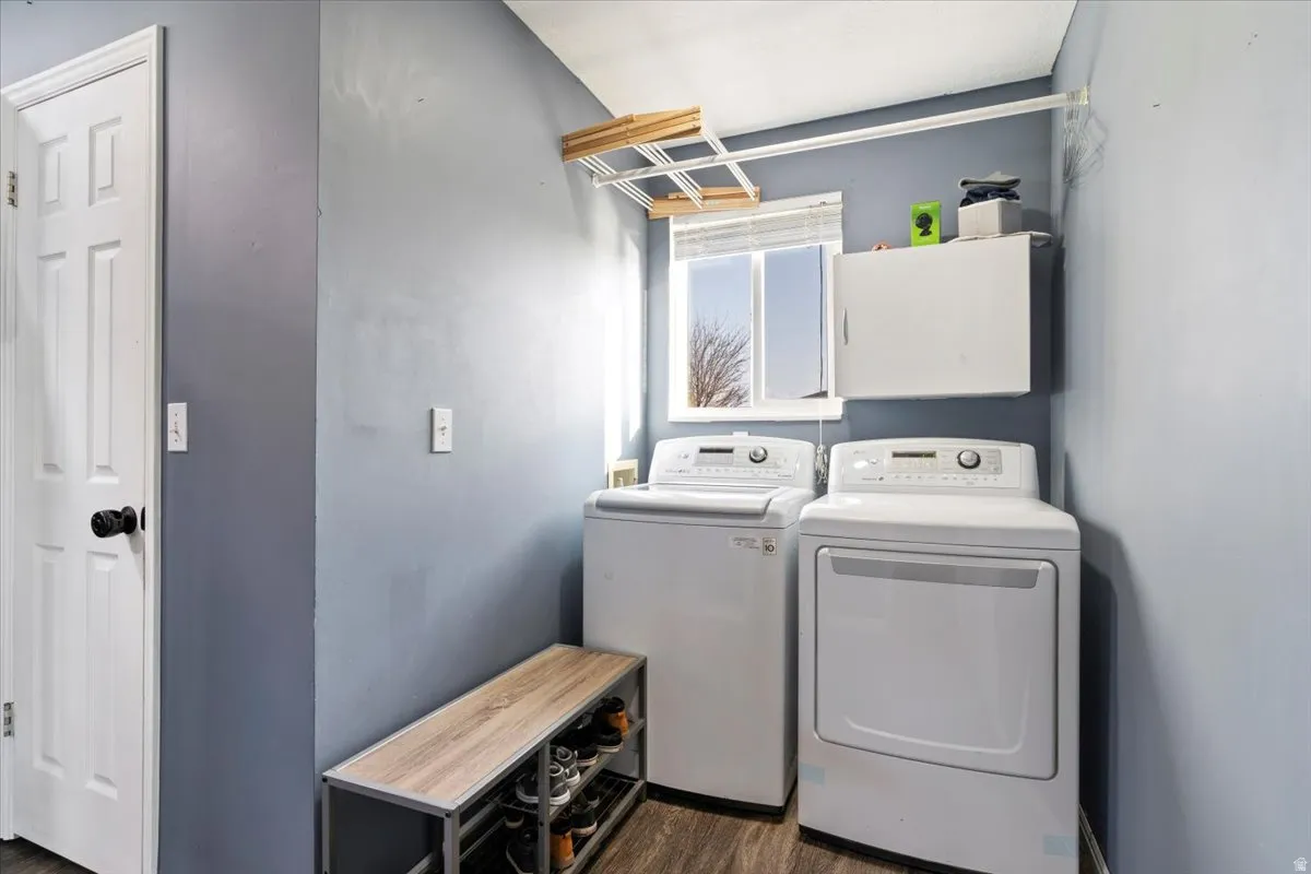 Laundry area featuring dark wood-style floors and washer and clothes dryer