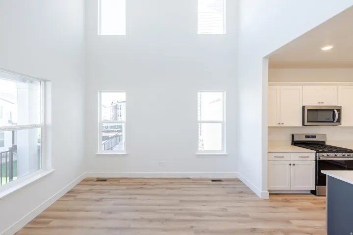 Two-story living area with high ceilings and multiple windows