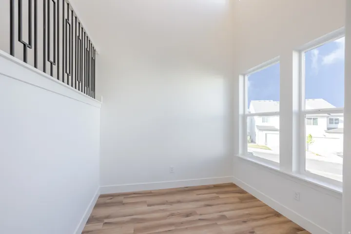 Open-concept room featuring wood-finish flooring, white walls, and bright windows