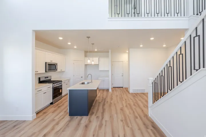 Open-concept interior featuring light wood-finish flooring throughout the main level