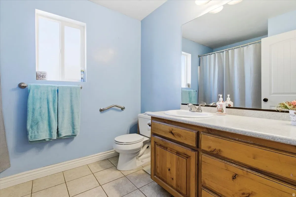 Bathroom with a shower with shower curtain, vanity, and light tile patterned floors