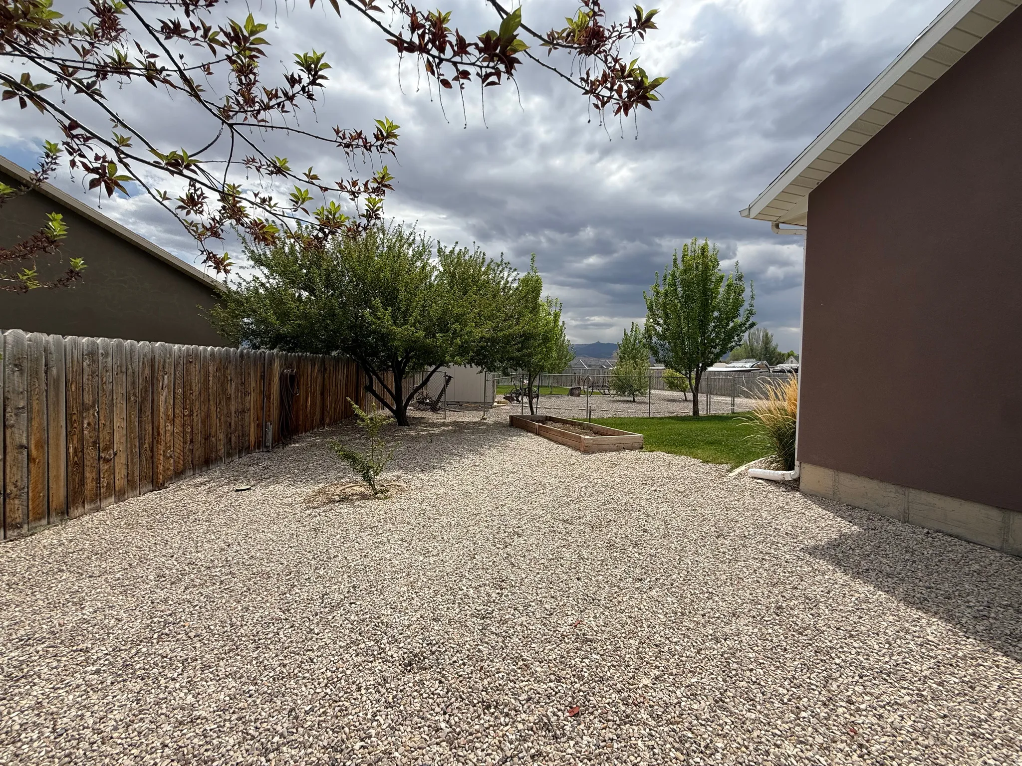 Gravel-covered yard with a wooden privacy fence
