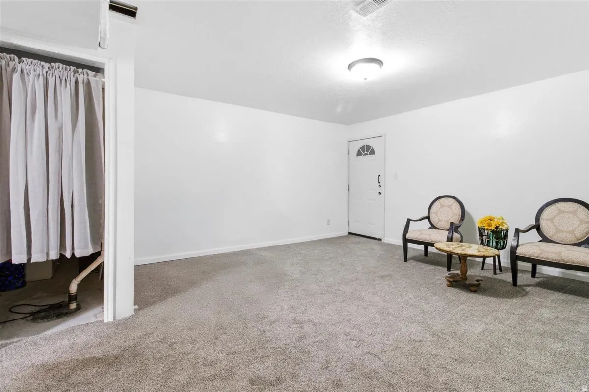 Unfurnished room featuring light colored carpet and a textured ceiling