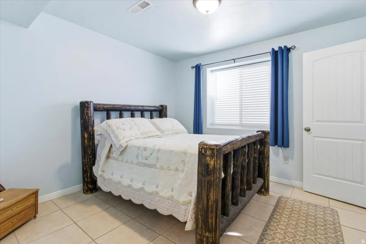 Bedroom with baseboards and light tile patterned flooring