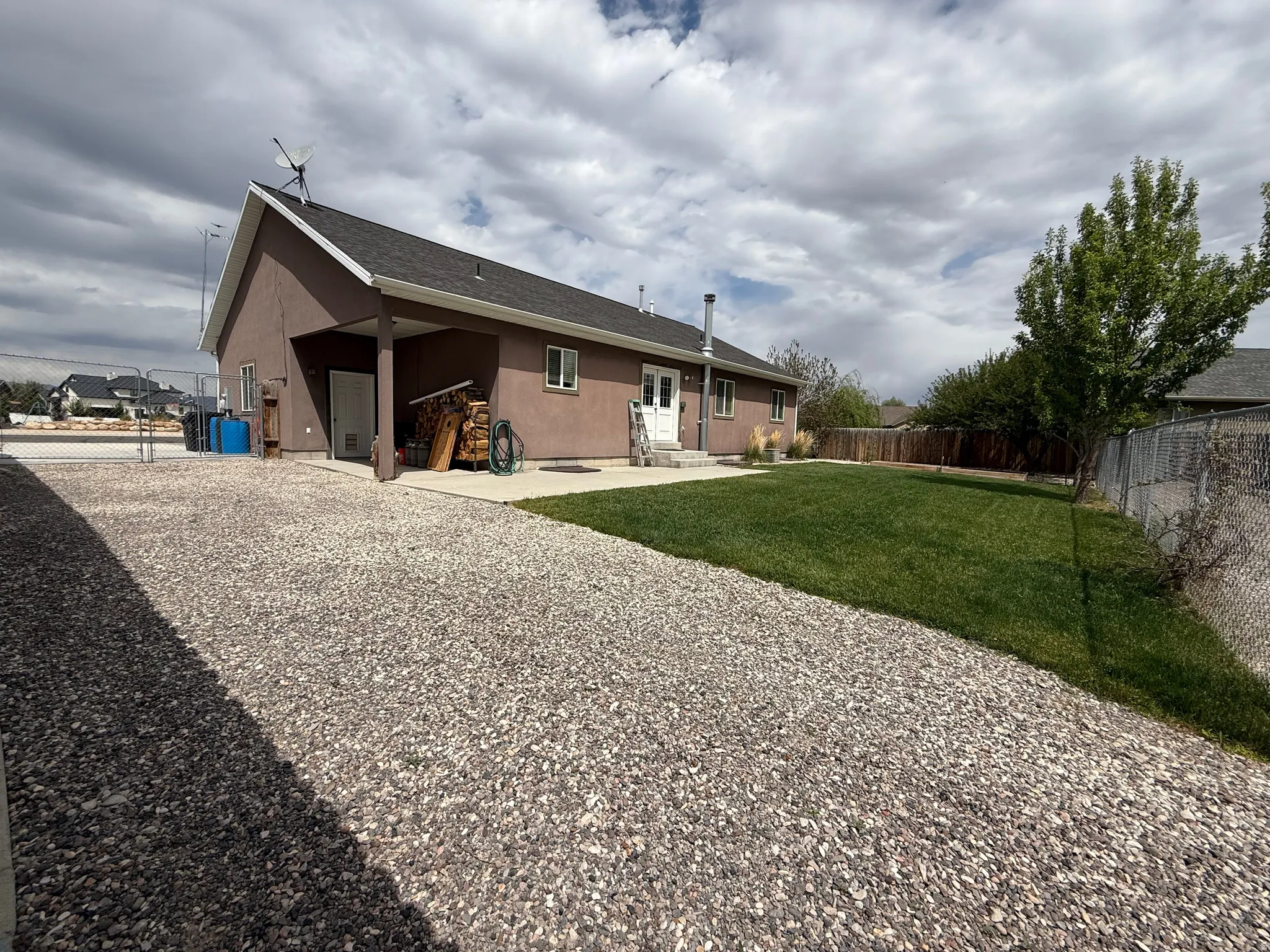 Exterior with a gravel driveway, covered entrance, and a sloped roof