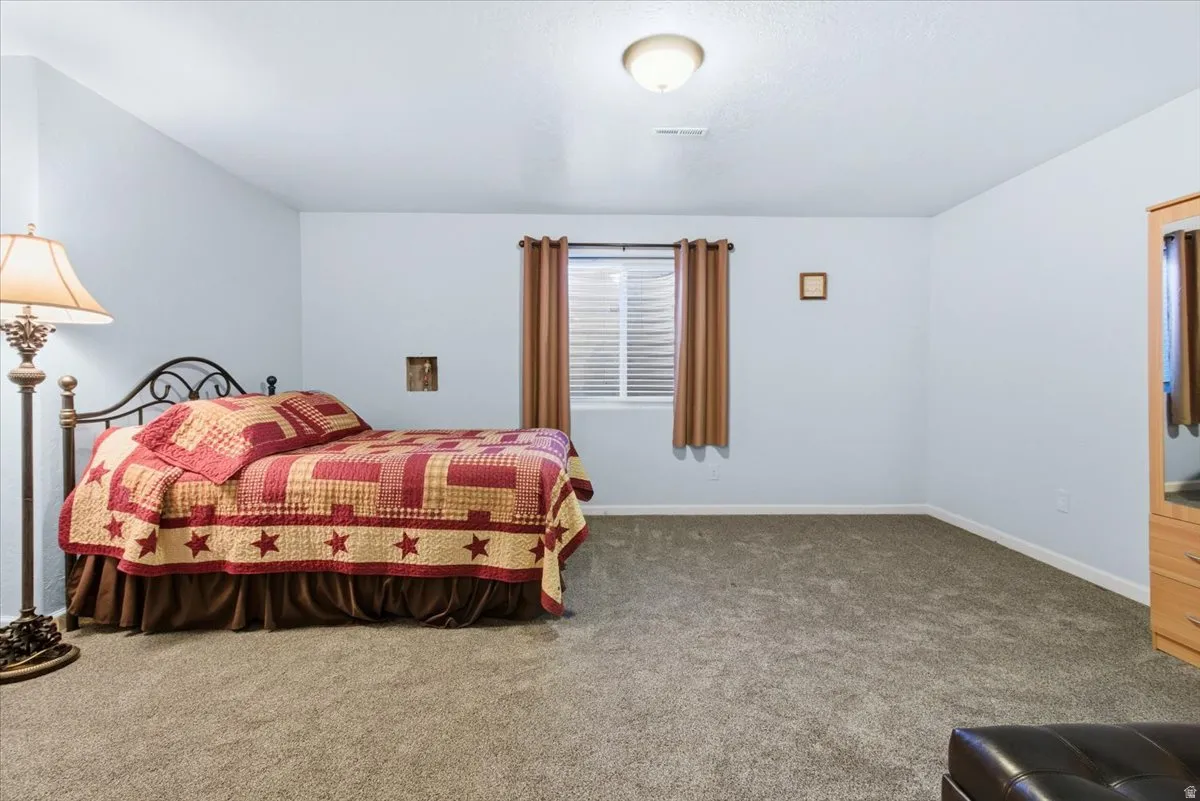 Carpeted bedroom featuring baseboards