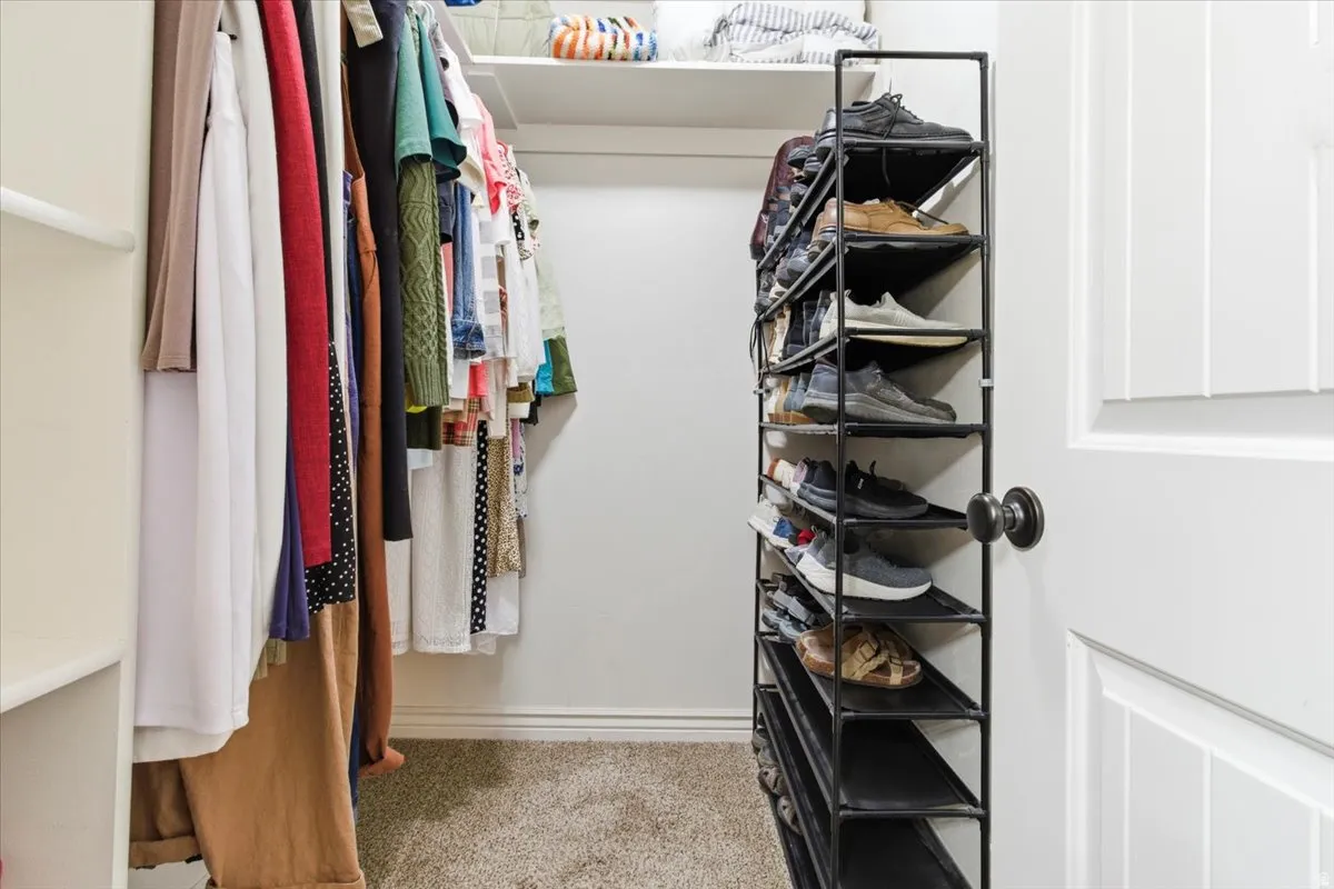 Spacious closet with light carpet