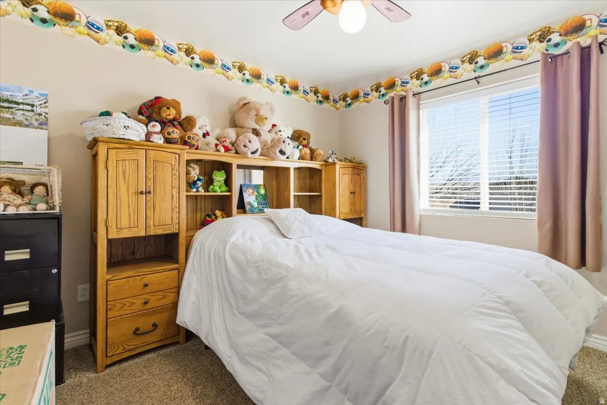 Bedroom with dark colored carpet and a ceiling fan