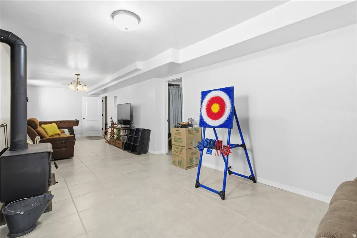 Living room with a wood stove and light tile patterned floors