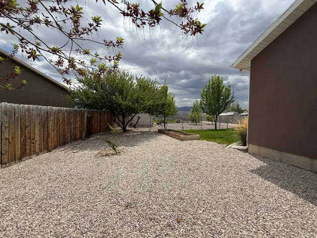Gravel-covered yard with a wooden privacy fence