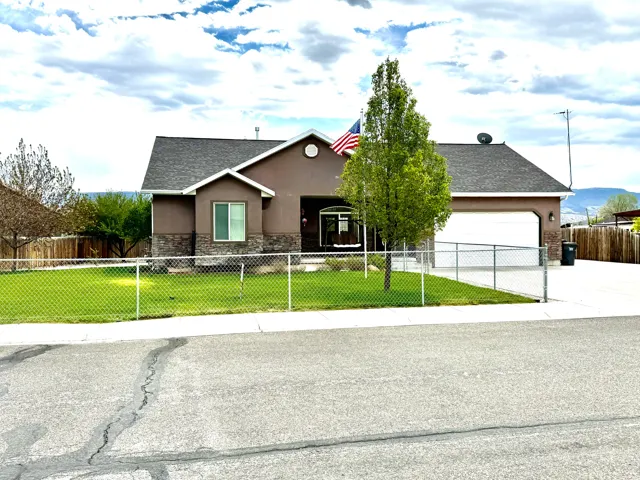 Single-story residence featuring a brown stucco exterior with stone accents and a dark shingle roof