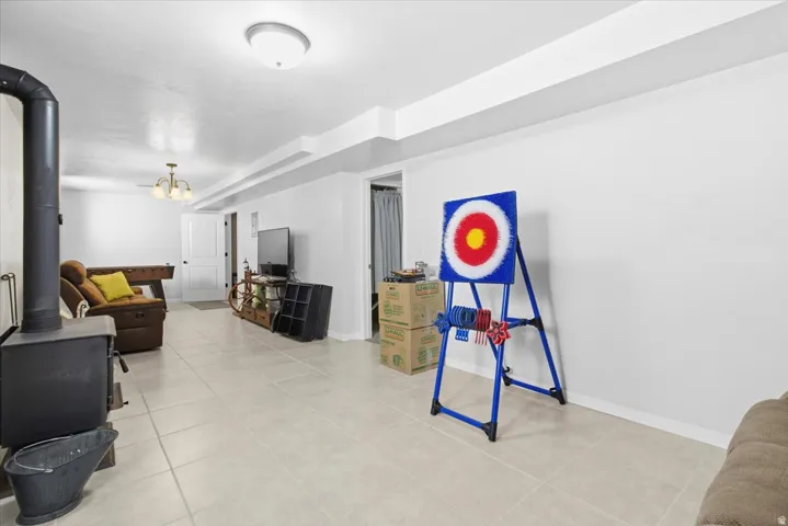 Living room with a wood stove and light tile patterned floors