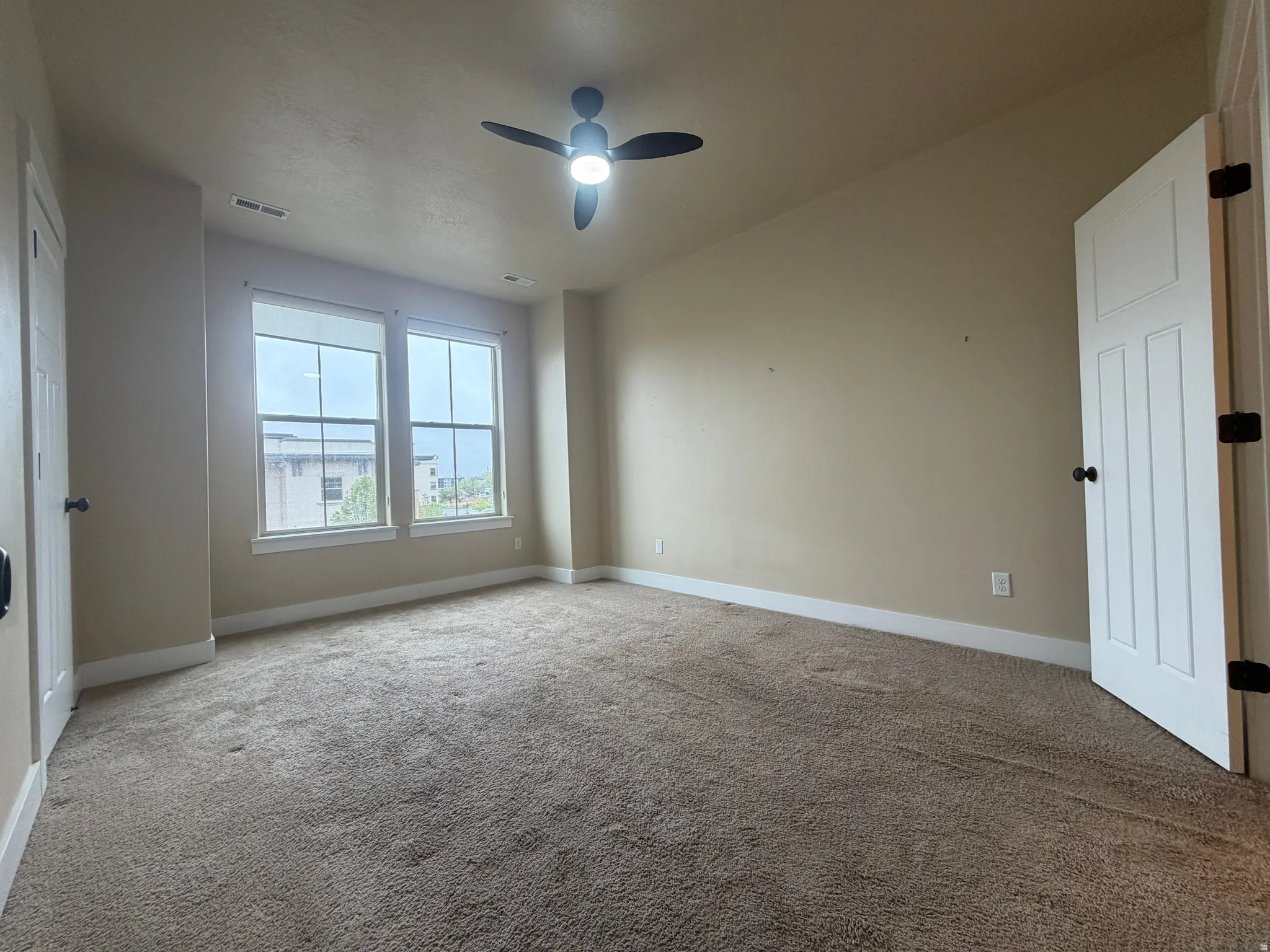 Spare room with carpet floors and a ceiling fan