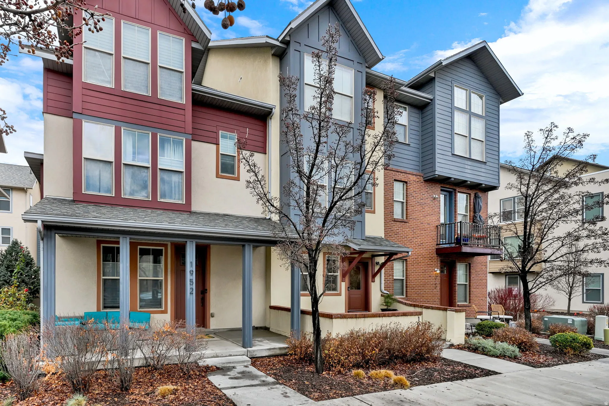 View of front facade with stucco siding, roof with shingles, and a porch