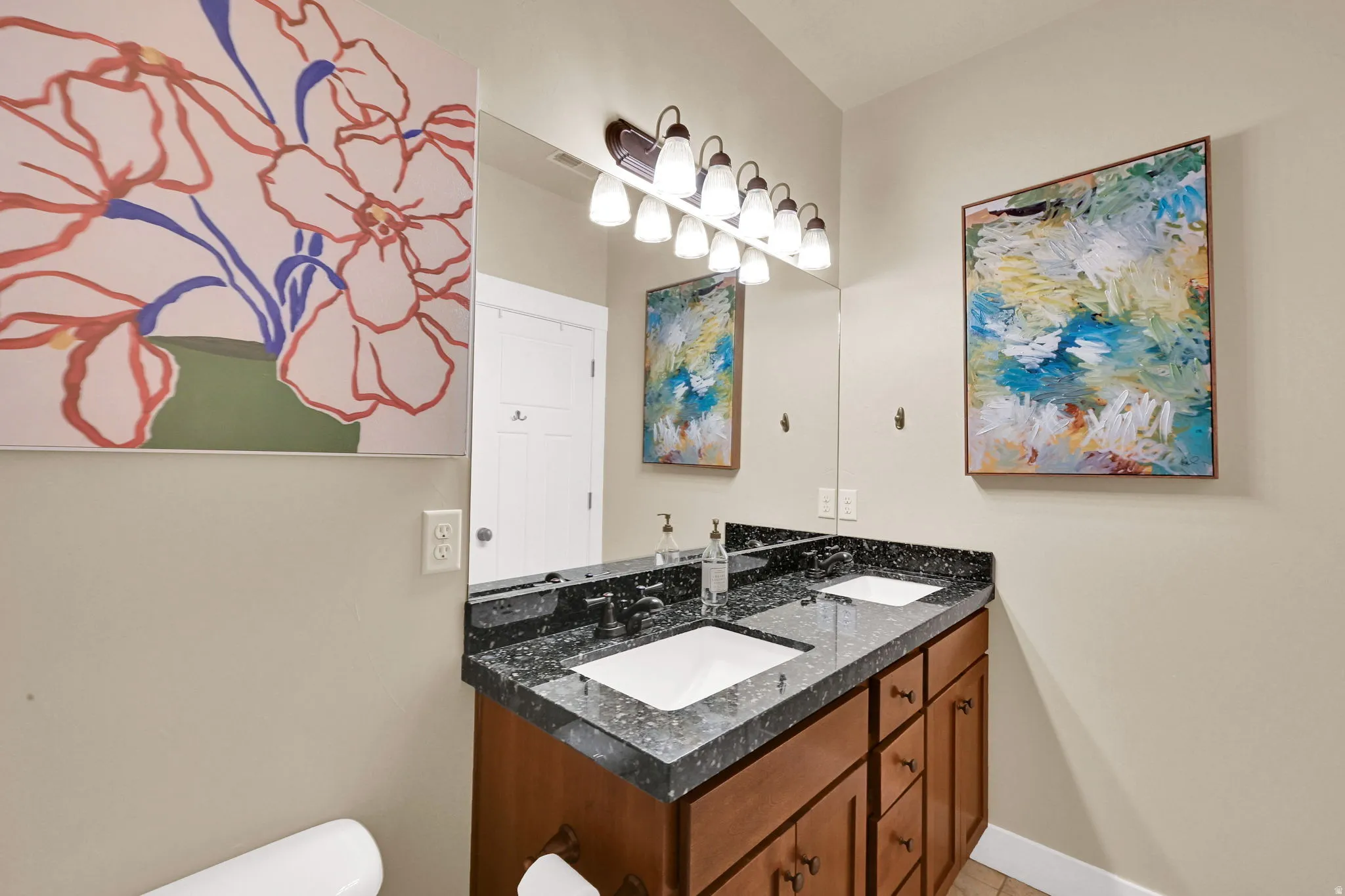 Bathroom with double vanity and toilet