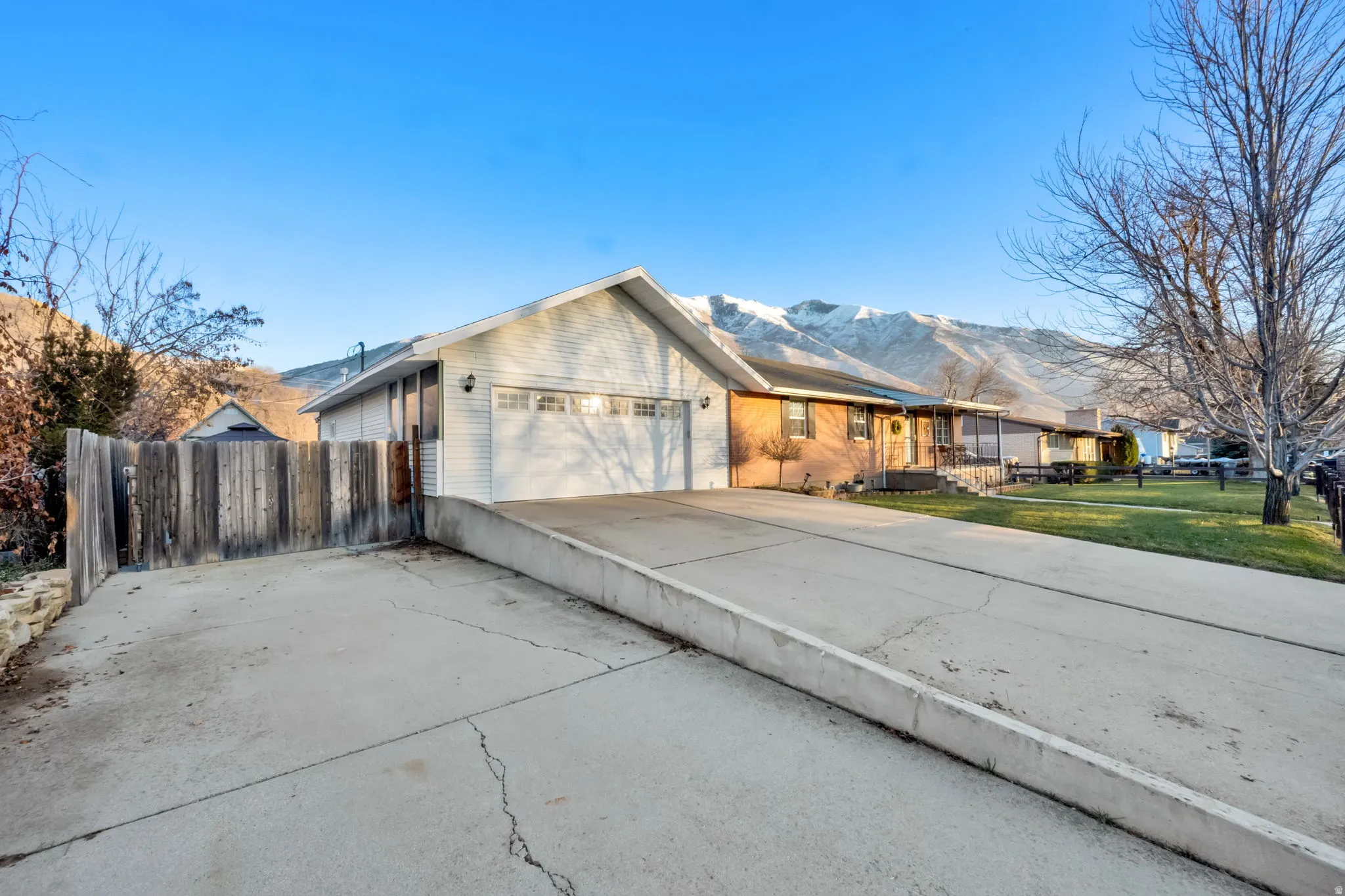 Single story home with concrete driveway, a mountain view, and an attached garage