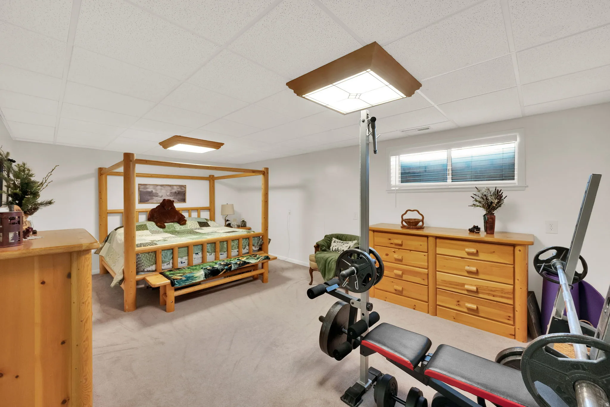 Exercise room with a paneled ceiling and light colored carpet