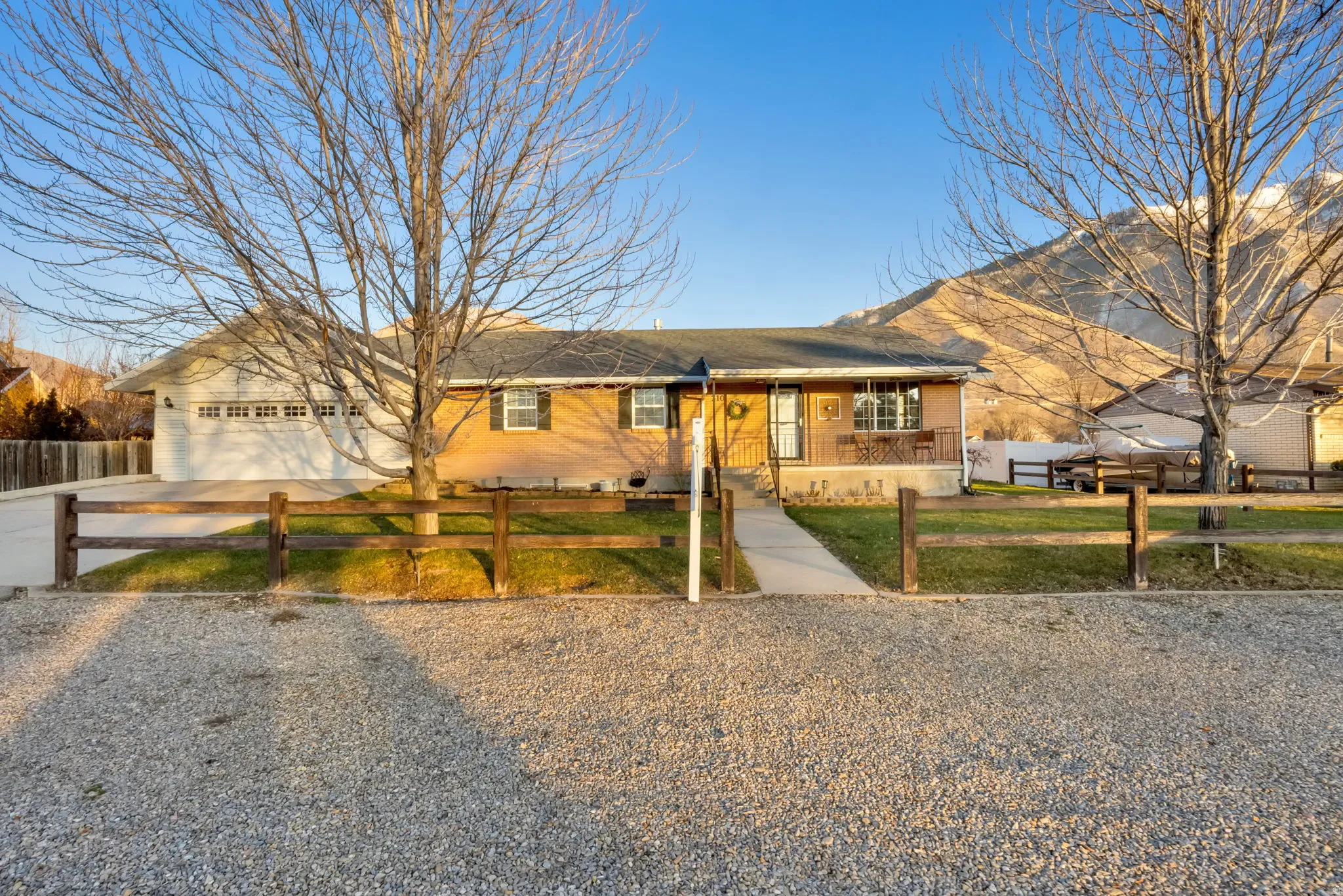 Single story home with concrete driveway, a fenced front yard, brick siding, and a garage