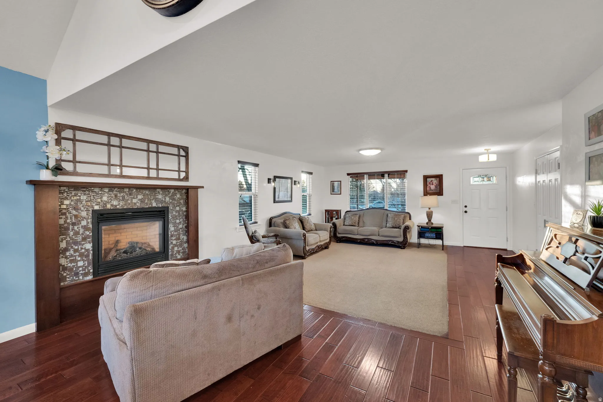 Living room with a tile fireplace and dark wood finished floors
