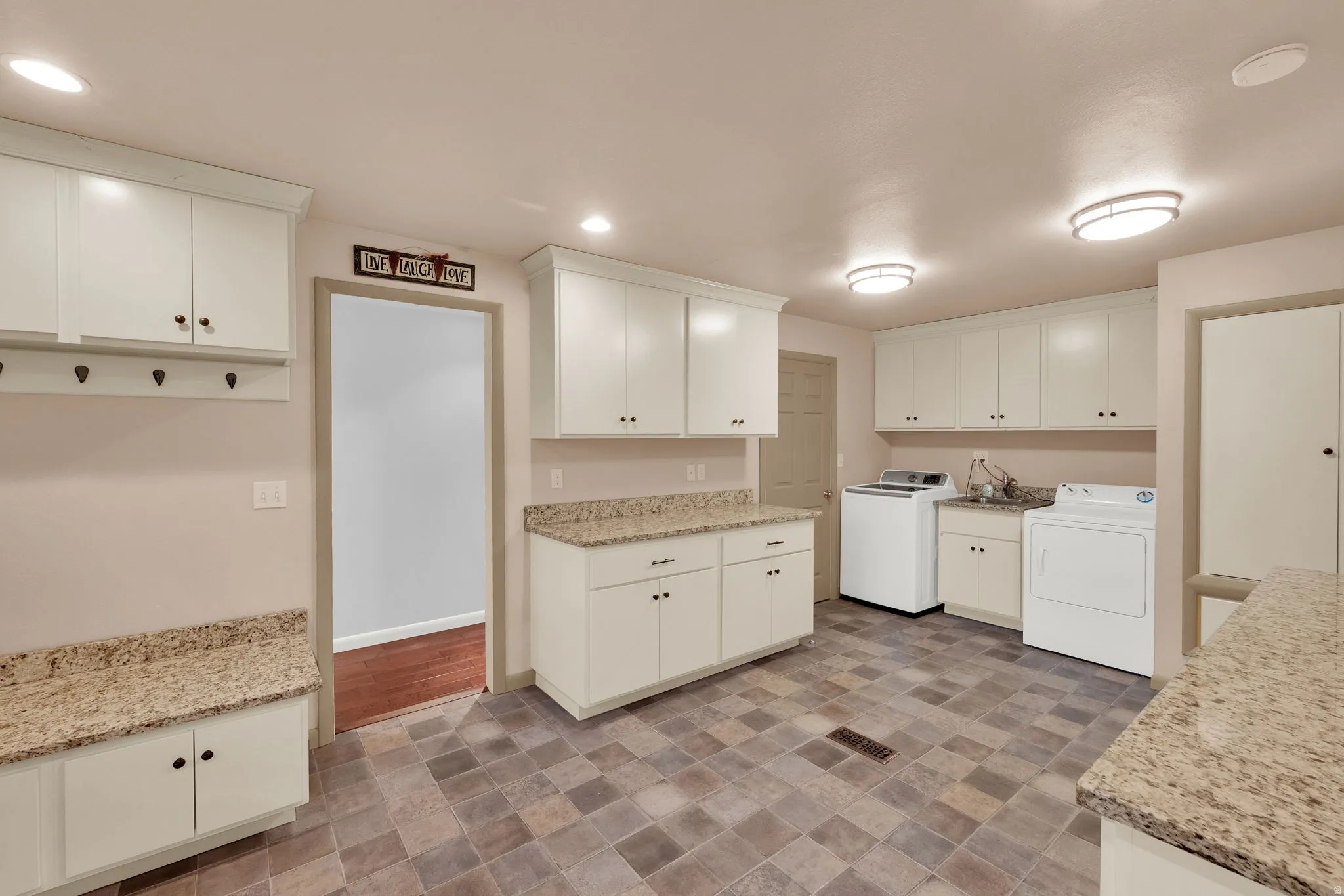 Laundry room with washer / dryer, recessed lighting, stone finish floors, and cabinet space