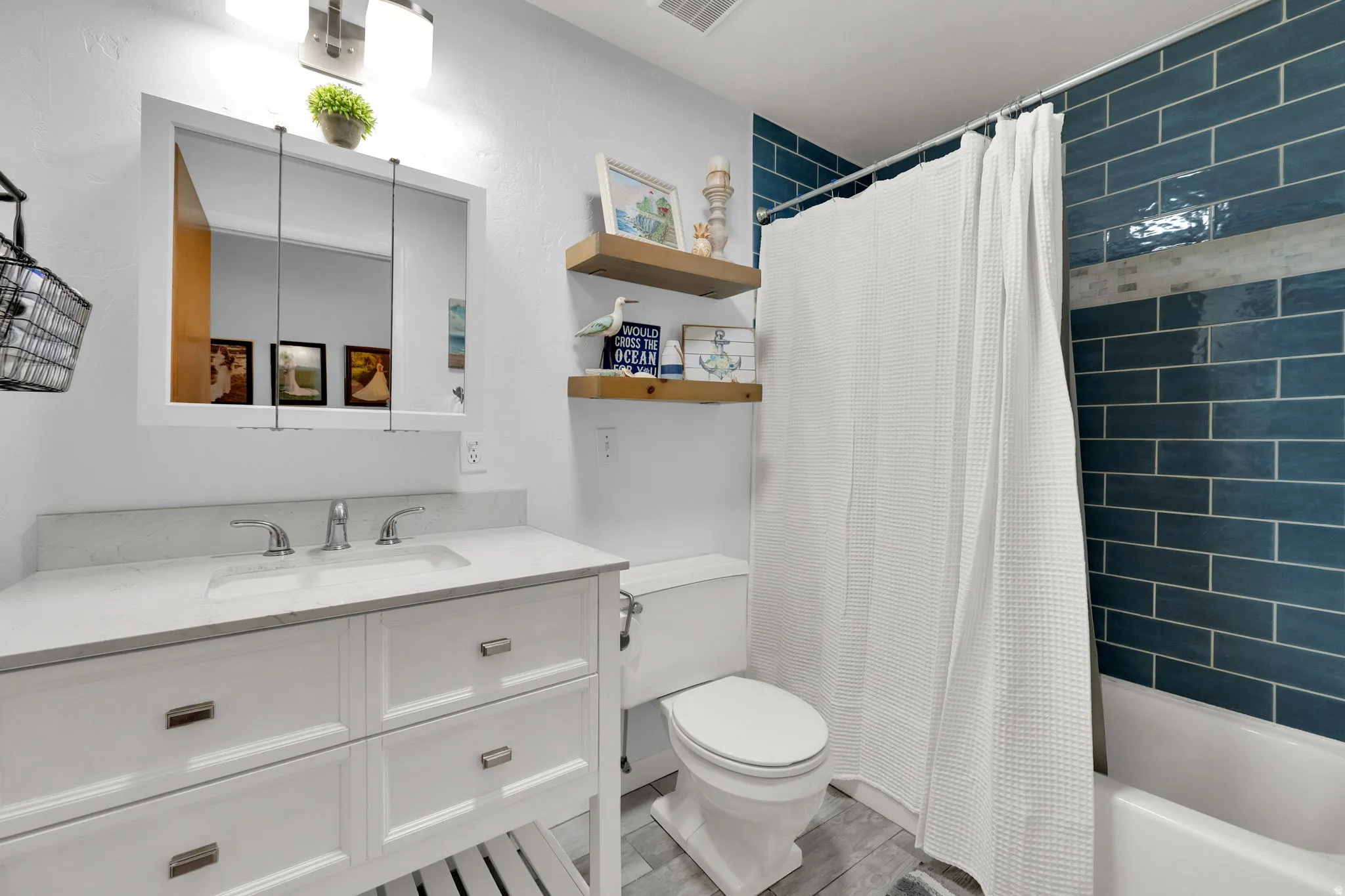 Full bathroom with shower / tub combo and vanity